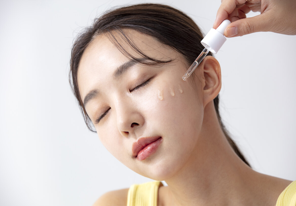 스포이드로 앰플을 볼에 떨어뜨리며 피부를 진정시키는 모습