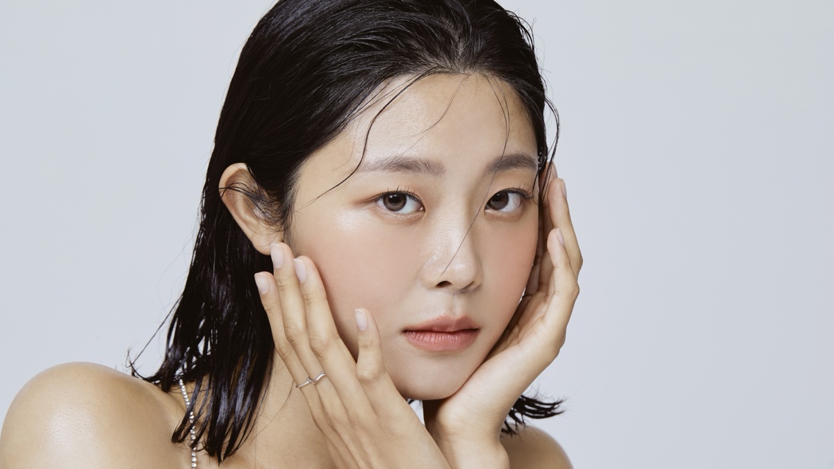 두 손으로 볼과 턱선을 감싸고 얼굴 윤곽을 살피는 여성