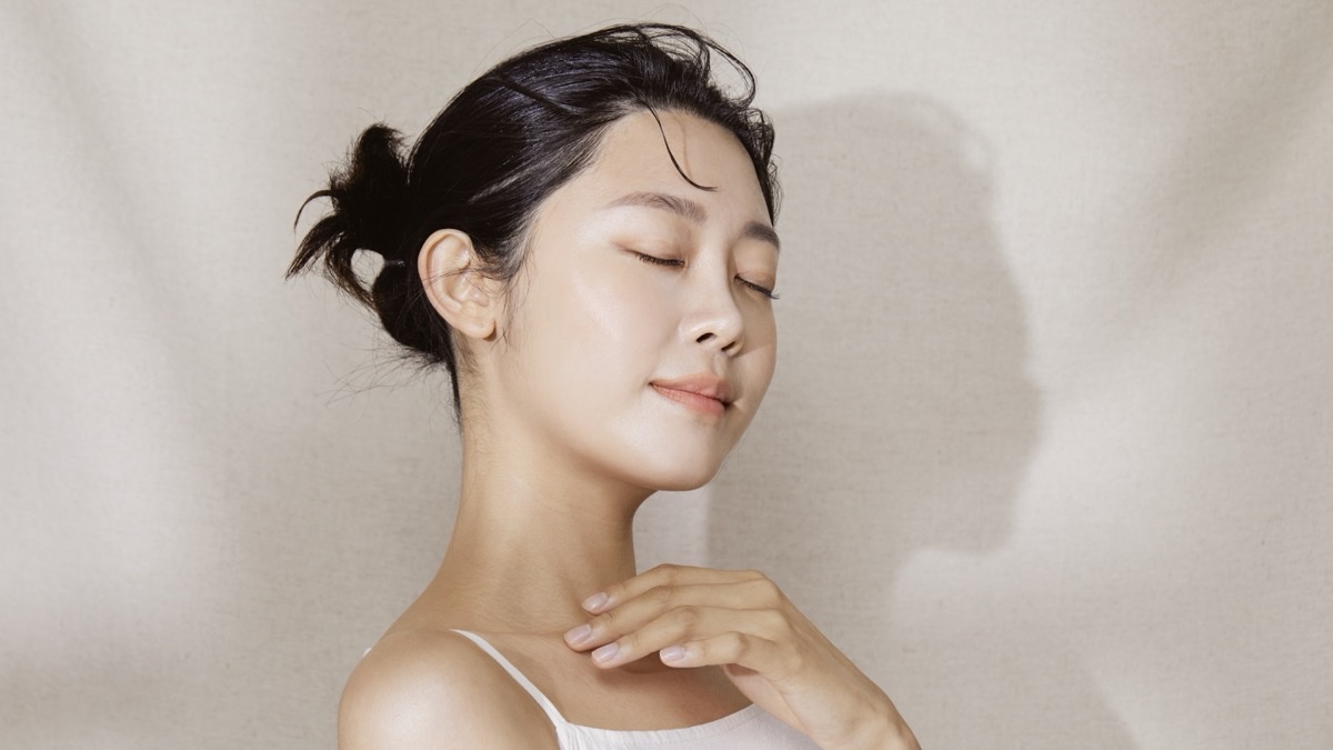 눈을 감고 손끝을 목선에 댄 여성의 맑은 피부 옆얼굴